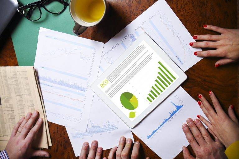 Business team hands at work with financial reports and a tablet